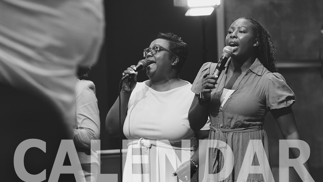 Two vocalists singing into microphones